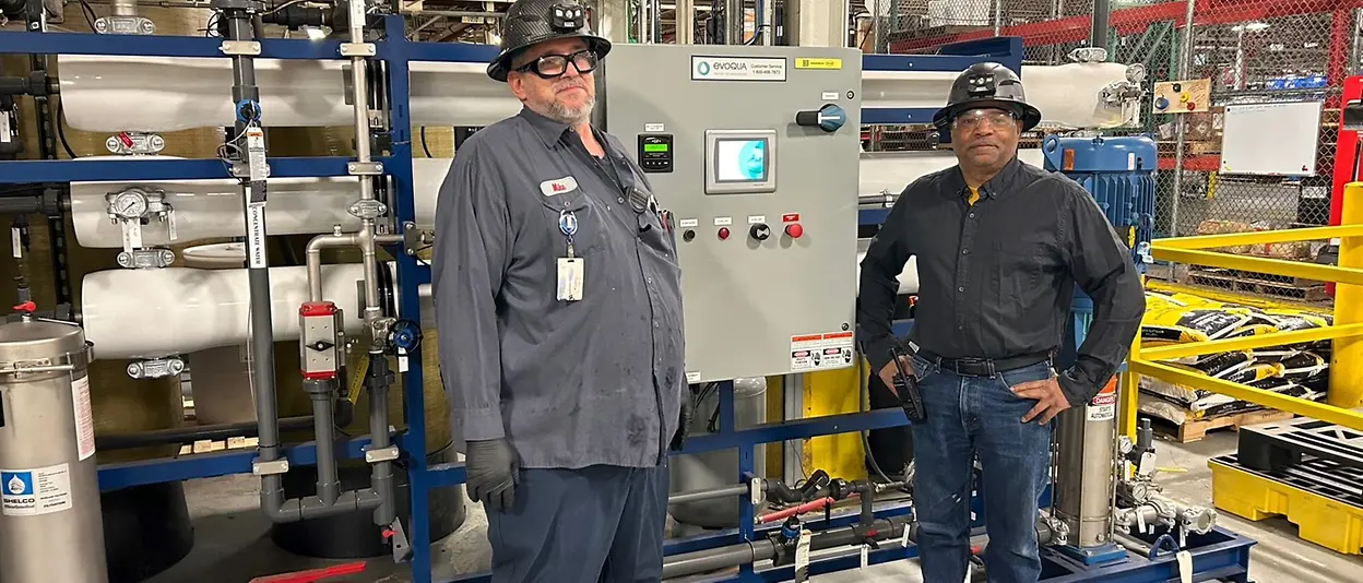 Facility employees stand in front of newly installed reverse osmosis unit