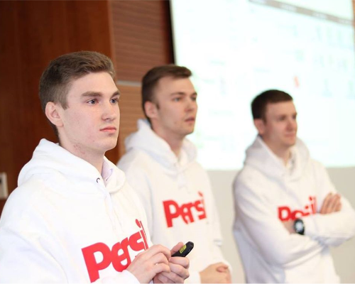 Trzech pracowników Henkla ubranych w sweter Persil i prowadzących prezentację