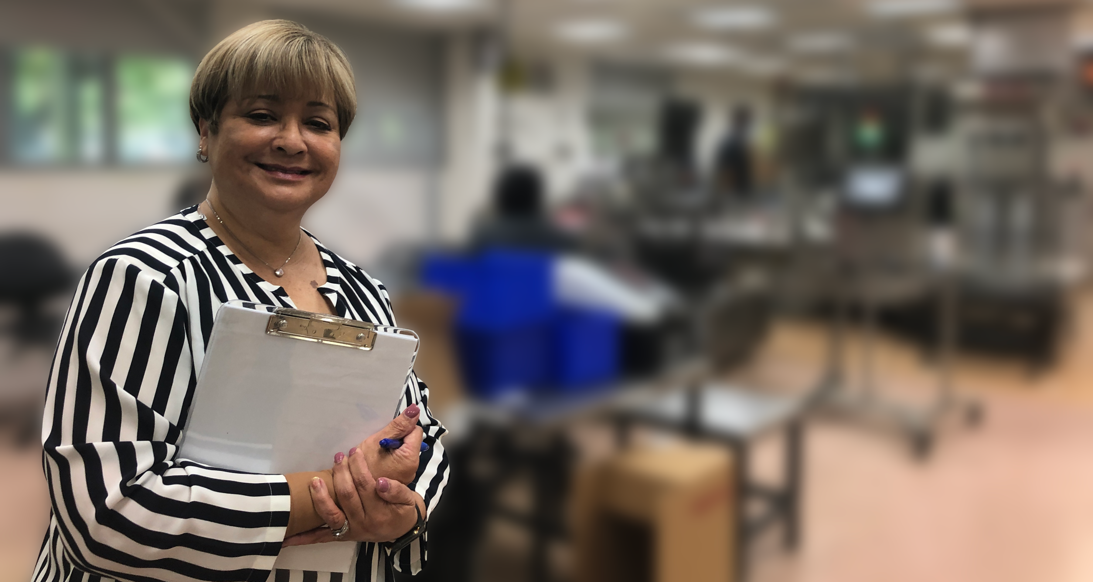 Woman holding clipboard smiling at camera