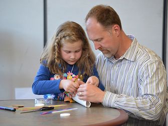 Employee Bart Drelichowski and his daughter Maya work on their balloon-powered racecar.