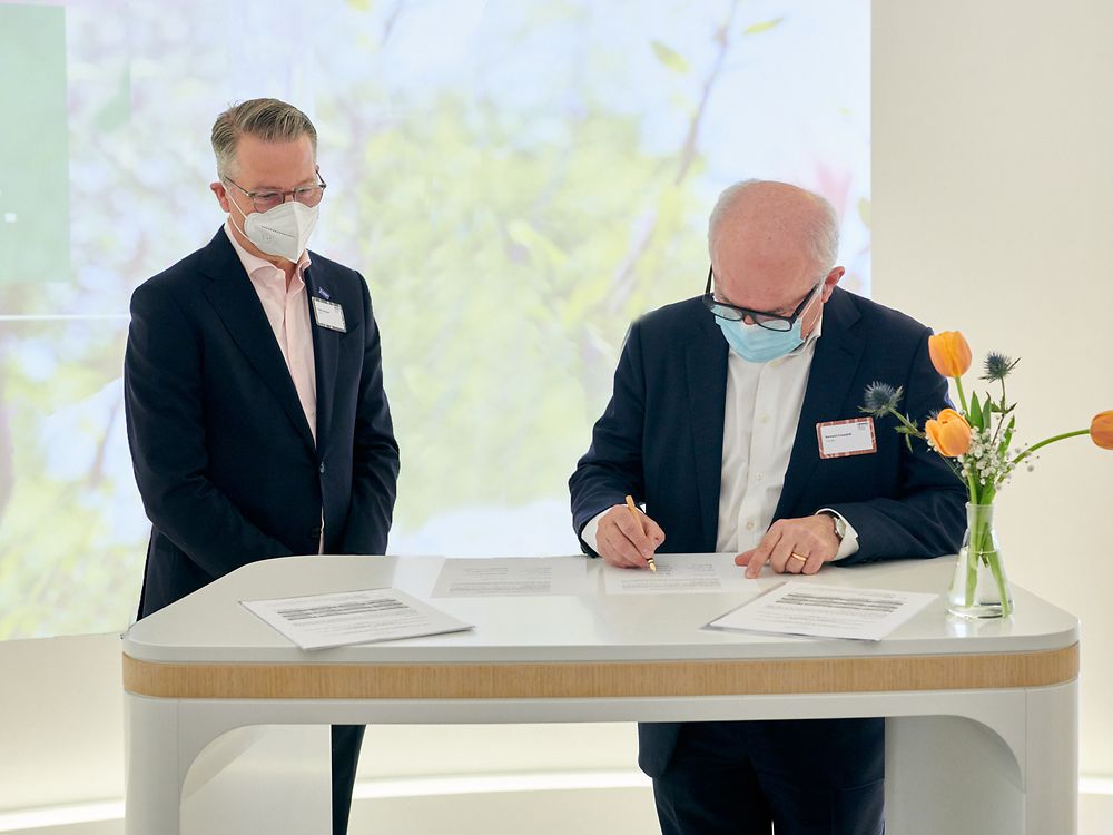 The two representatives of BASF and Henkel are signing the contract. 