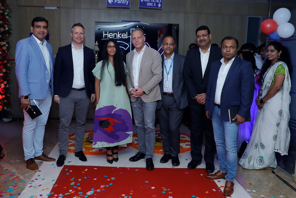 Nilesh Mhatre, Frank Tenbrock, Roshni Nadar Malhotra, Michael Nilles, Ashish Gupta, Sunil Kumar und Mithun Kumar (von links) stehen in einem Halbkreis im Global Technology Center. 