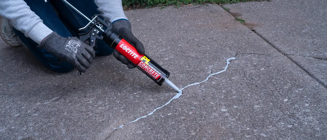 Person using LOCTITE® PL Self-Leveling Sealant to repair pavement crack