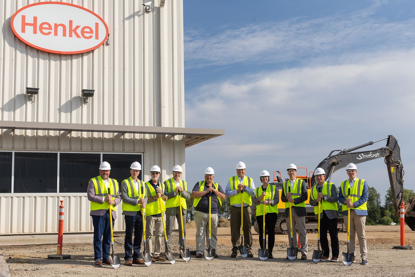 photo of Brandon groundbreaking with a group of Henkel employees posing with hard hats and shovels