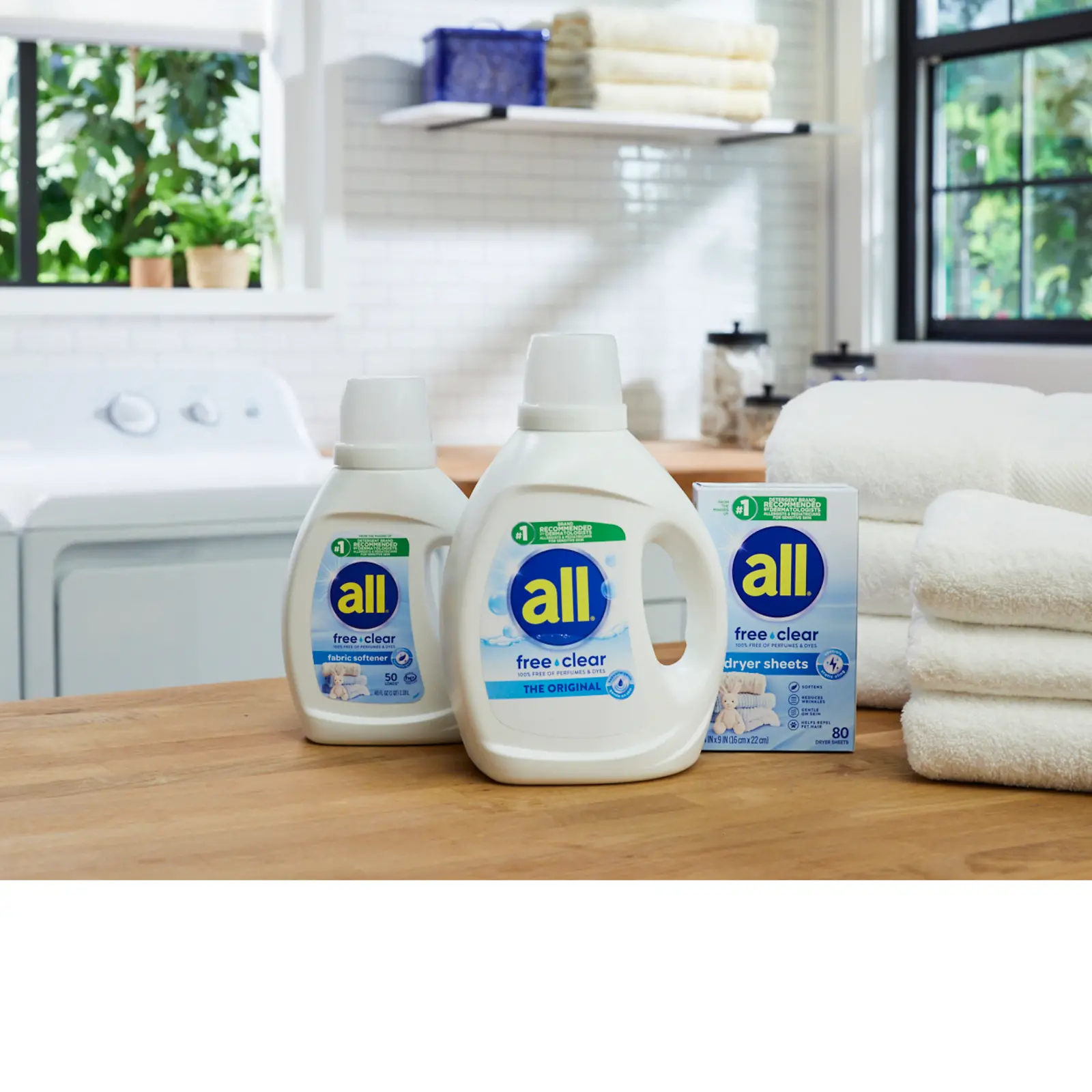 Woman holds child in a laundry room, using a bottle of all free clear detergent