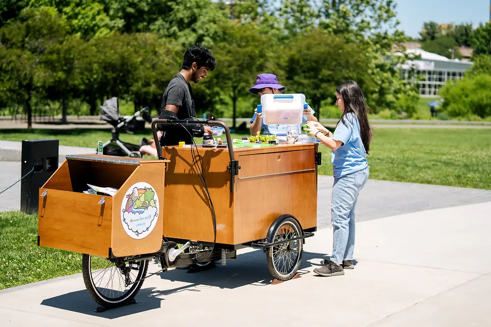 A mobile learning cart branded with Henkel’s Researchers’ World and a child exploring it.