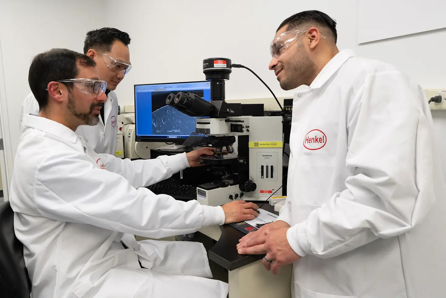 People in lab coats discuss test results in the Analytical Solutions Lab at the Technology Center Bridgewater.