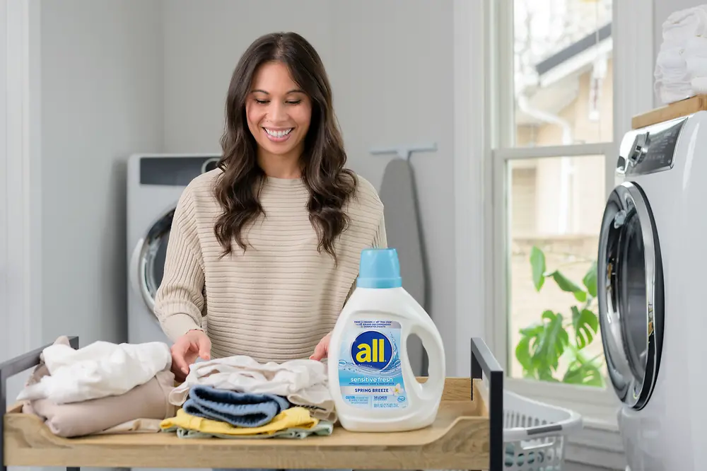 woman doing laundry with all® sensitive fresh