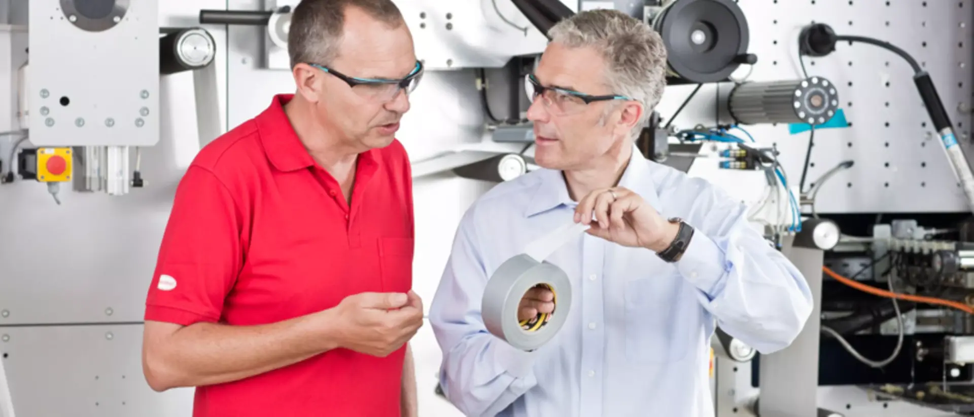 A photo of Henkel employees holding a roll of tape.