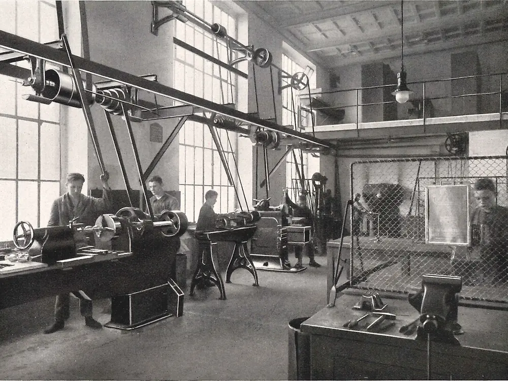 學徒在金屬加工車間操作設備。