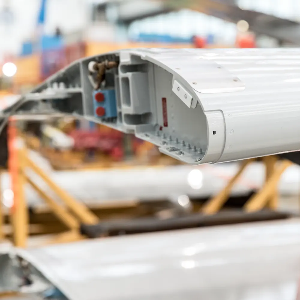 Interior view of a partially assembled aircraft wing, showing structural components where adhesives are applied.