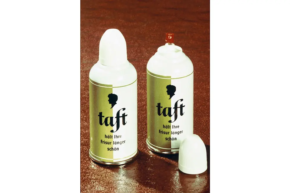 兩隻復古風格的“Taft”髮膠包裝罐，紅棕色表面上配有白色蓋子和金色標籤。