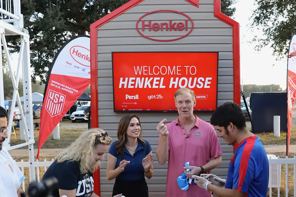 Alexi Lalas at a table with a group of other people with Loctite products
