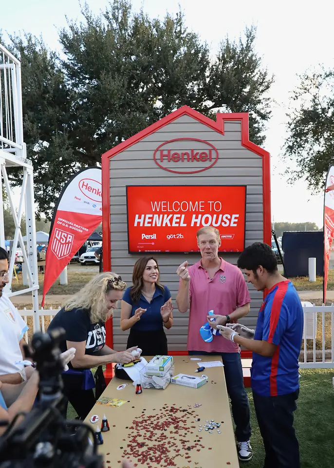 Alexi Lalas at a table with a group of other people with Loctite products