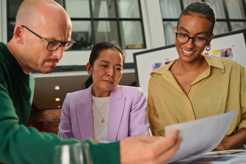Ein Mann und eine Frau sitzen an einem Tisch, trinken Kaffee und lächeln sich an.