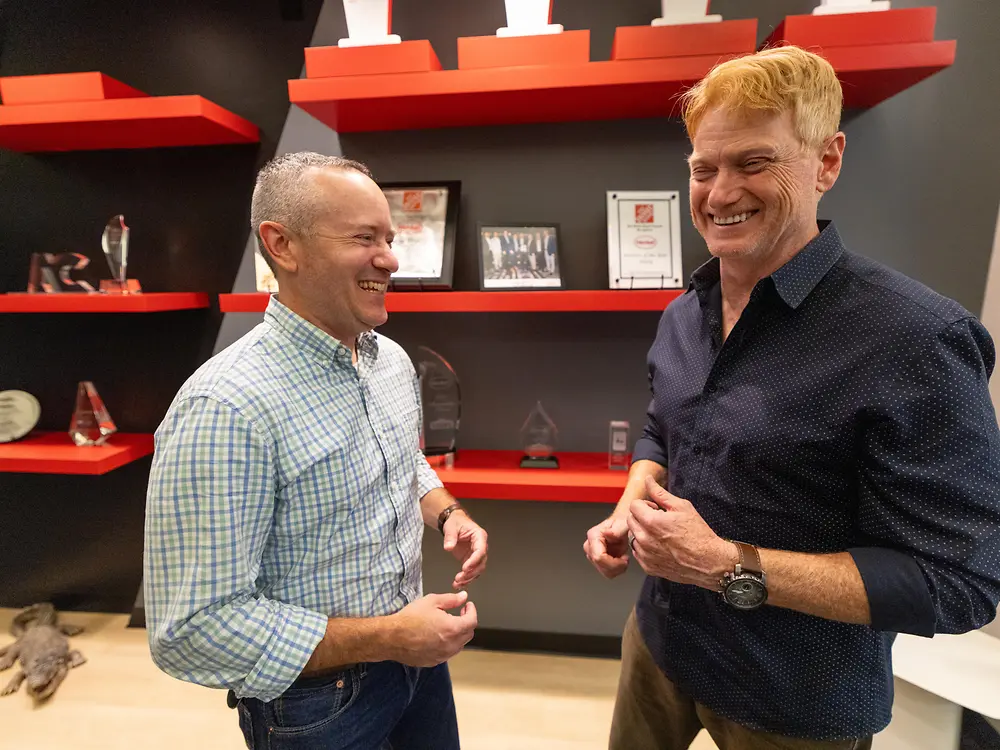Two Henkel employees laugh while having a conversation.