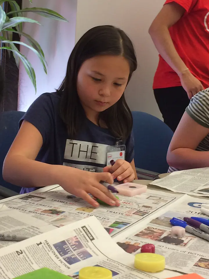 Sophia Lehmann decorates a magnet made from recycled hot melt adhesives at Henkel's Take Your Child to Work Day event in Bridgewater, New Jersey.