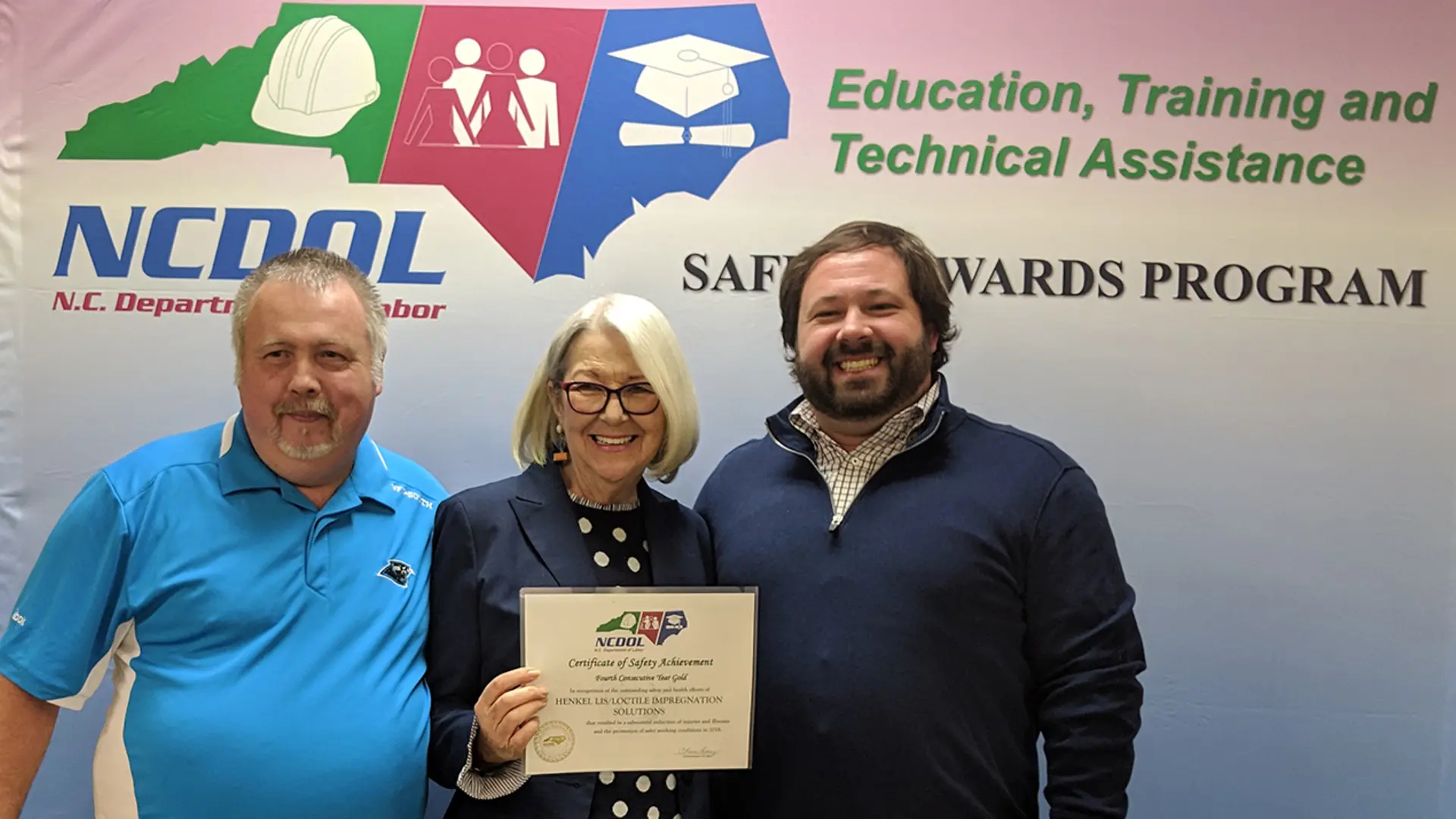 North Carolina Commissioner of Labor Cherie Berry presents the plant’s fourth consecutive Gold Certificate of Safety Achievement award to Henkel’s Charles McMurry, Jr. (left) and Plant Manager Trent Mason.