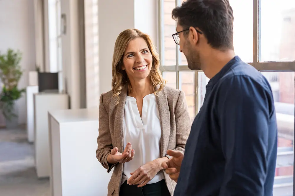 男士和女士正站在辦公室談話